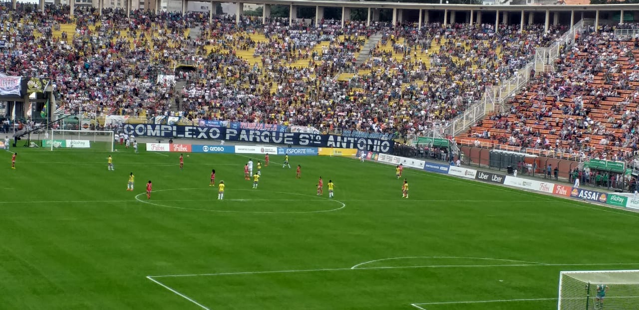 Imagem do estádio do Pacaembu com os jogadores em campo e a plateia na arquibancada