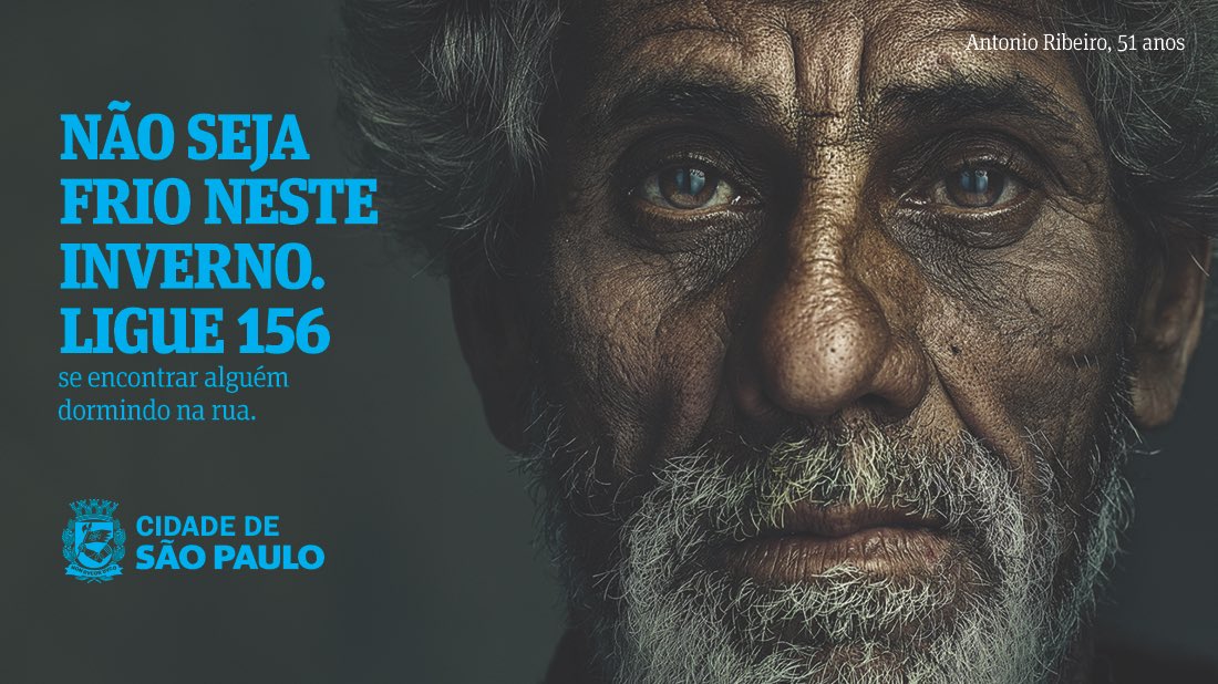 Close no rosto de homem em situação de rua com barba grisalha e pele negra. No canto superior direito, lê-se Antônio Ribeiro, cinquenta e um anos. No canto inferior esquerdo, lê-se não seja frio neste inverno, ligue um, cinco, meia, se encontrar alguém dormindo na rua. No canto inferior direito, brasão da Prefeitura de São Paulo e os dizeres Cidade de São Paulo.