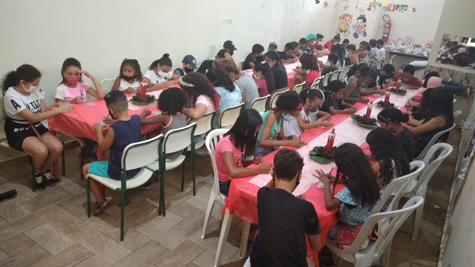 Crianças reunidas no refeitório aguardando o início da oficina de culinária