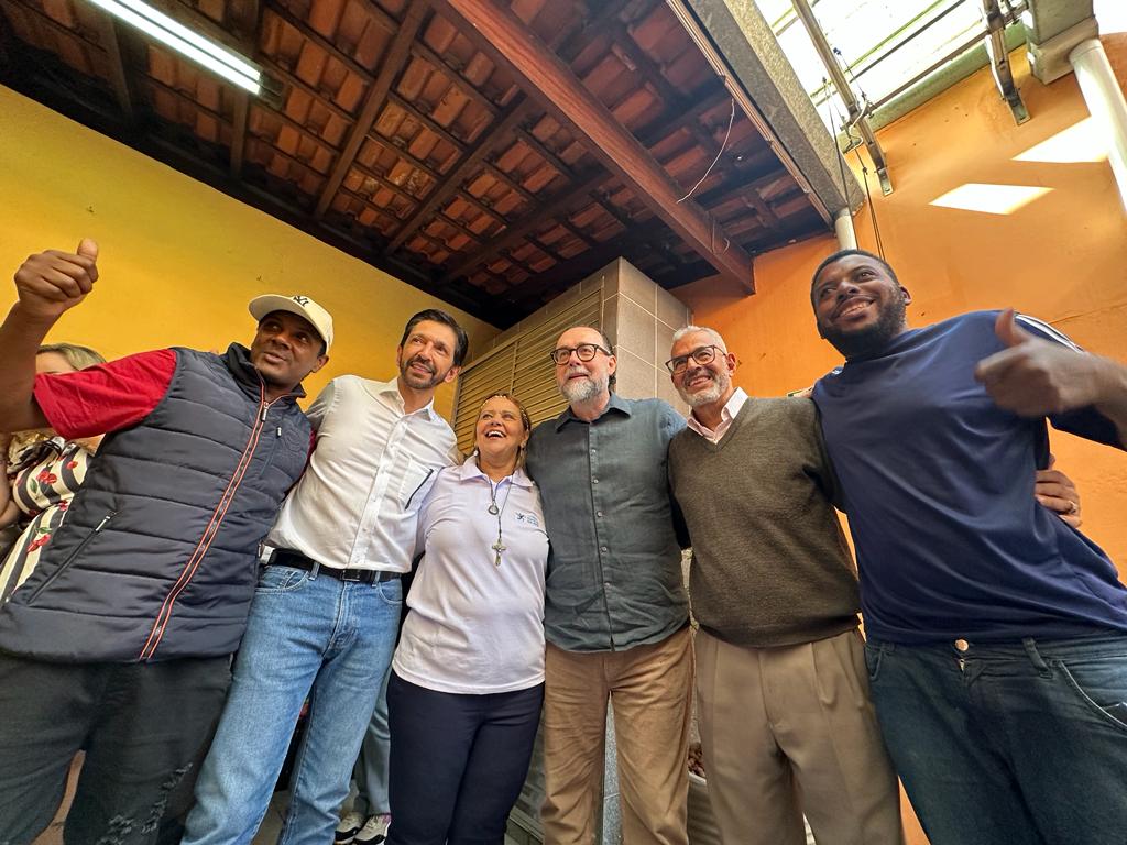 Foto tirada de um ângulo de seis pessoas, sorrindo e fazendo pose. Entre elas, estão o prefeito Ricardo Nunes e o secretário municipal de Assistência e Desenvolvimento Social, Carlos Bezerra Jr.
