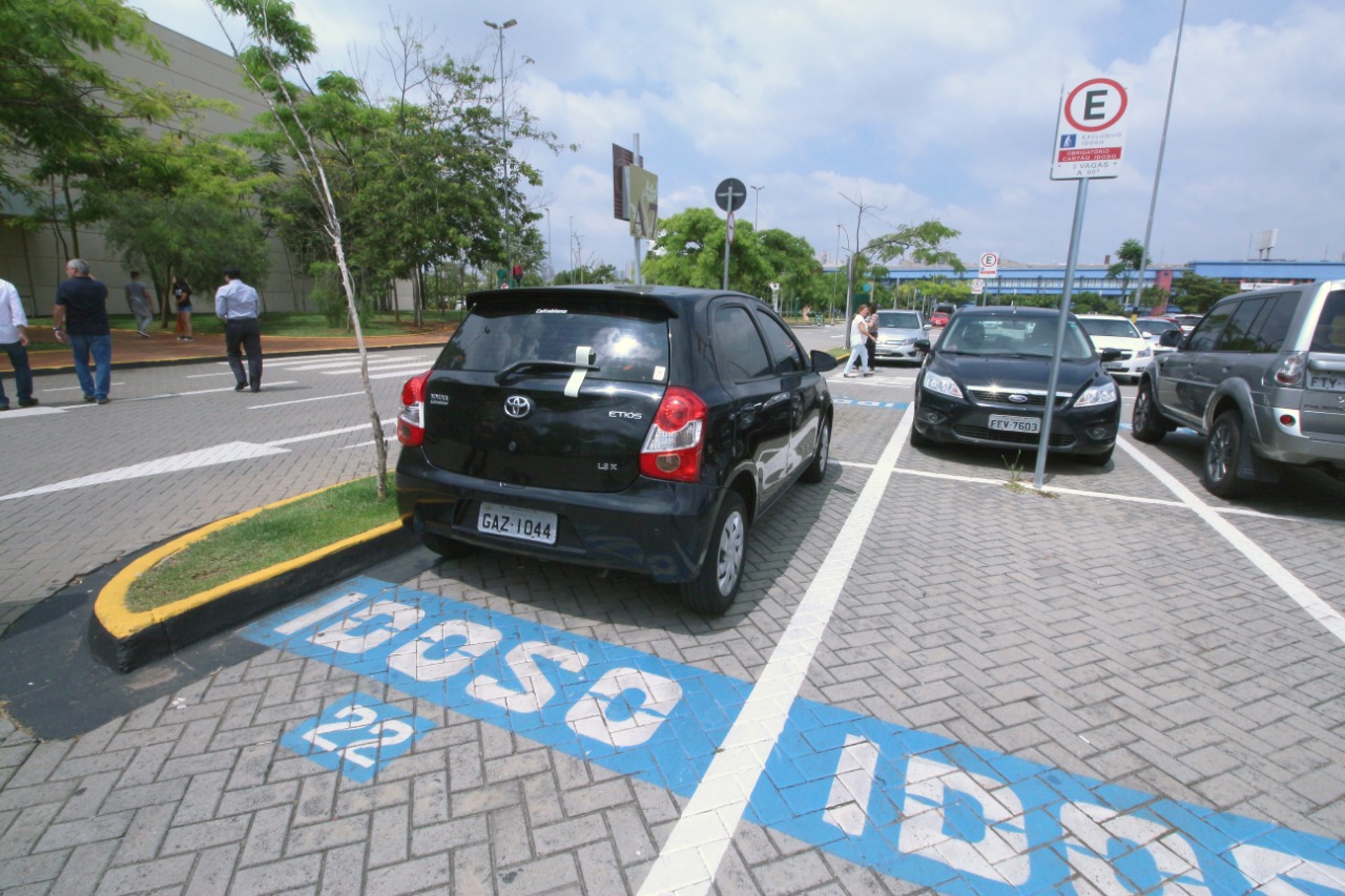 Carro estacionado em uma vaga reservada, no estacionamento do shopping. 