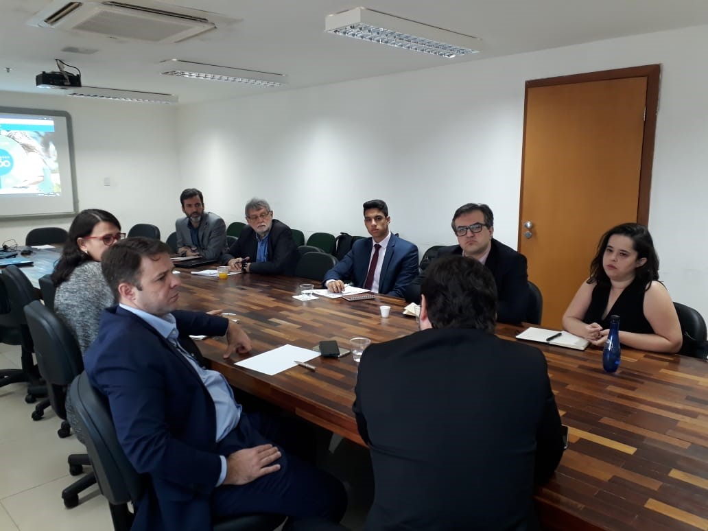 Representantes de várias cidades se reúnem em uma mesa.
