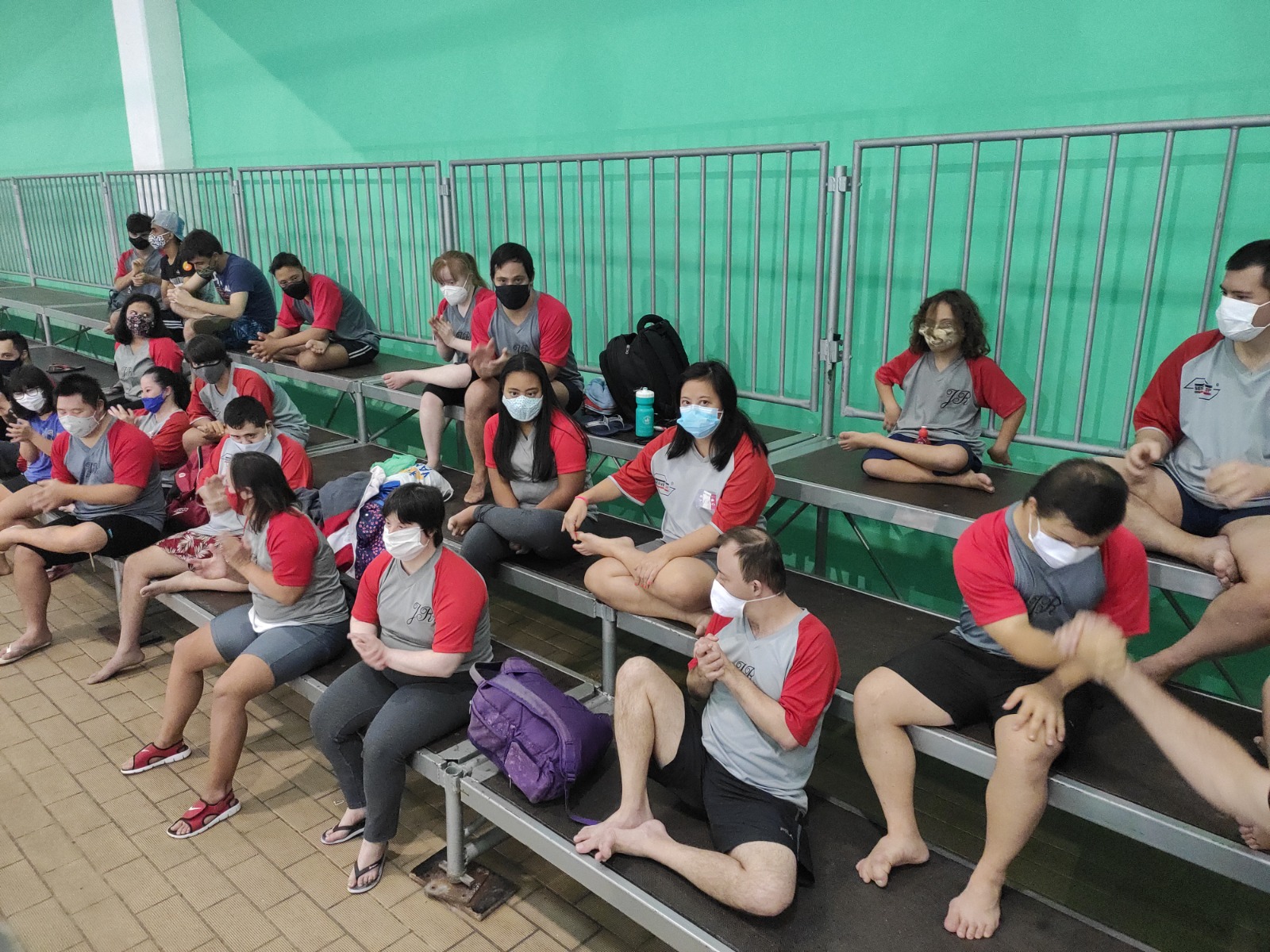 Na imagem, atletas com síndrome de down na arquibancada da piscina do Centro Olímpico de Treinamento e Pesquisa.
