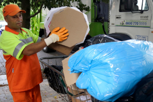 Coletor recolhe papelões em lixeira