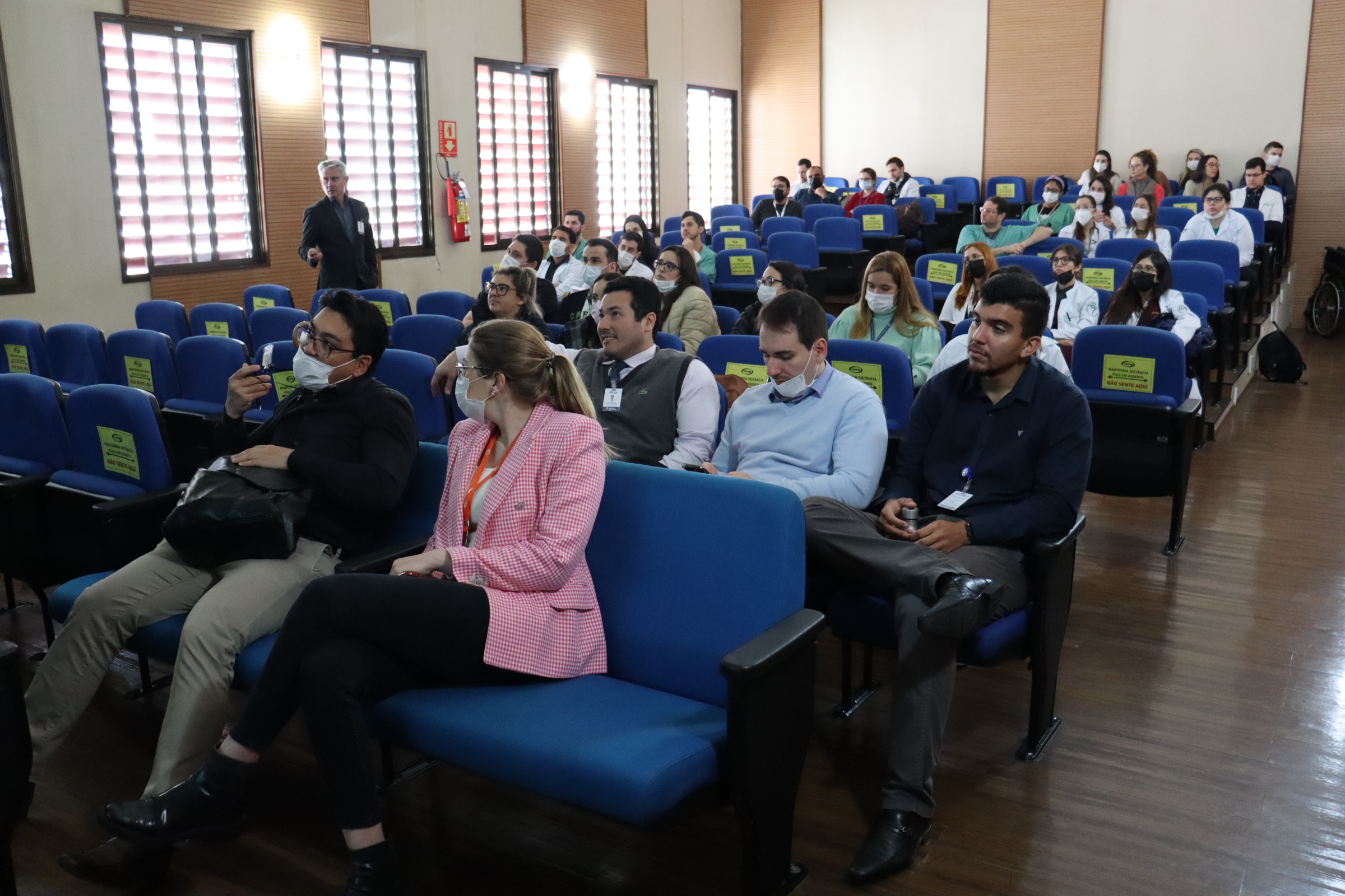 Imagem panorâmica do anfiteatro, mostrando o público sentado assistindo à aula