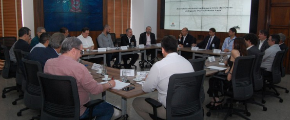 Imagem do Prefeito Bruno Covas junto com Secretários e Diretores das SPObras visualizando slide em reunião