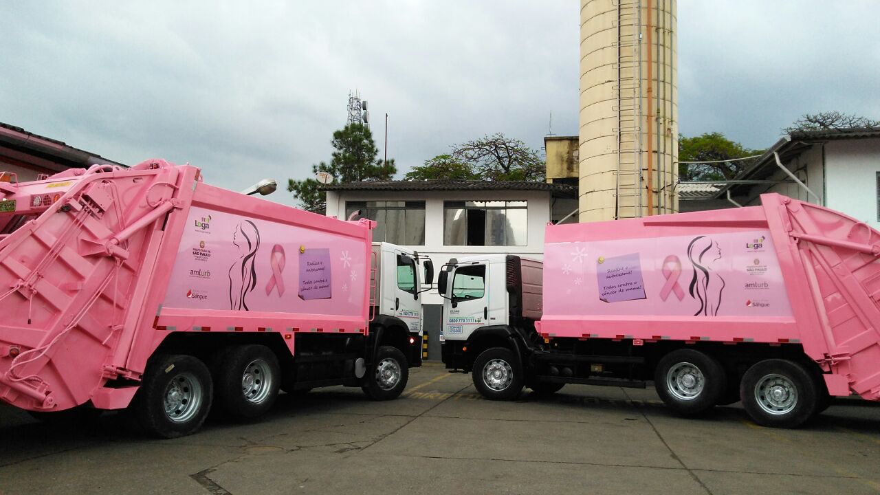 Dois caminhões pintados de rosa estacionados