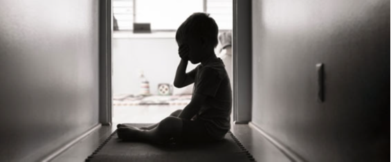 #PraTodosVerem Uma criança está sozinha no corredor de uma moradia. Aparece a silhueta da criança que aparenta estar chorando