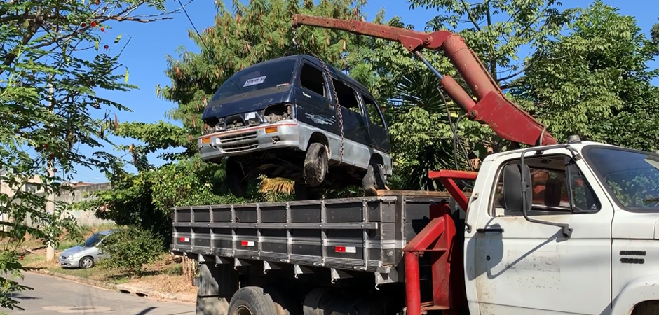 Foto de um caminhão da Prefeitura recolhendo um carro abandonado