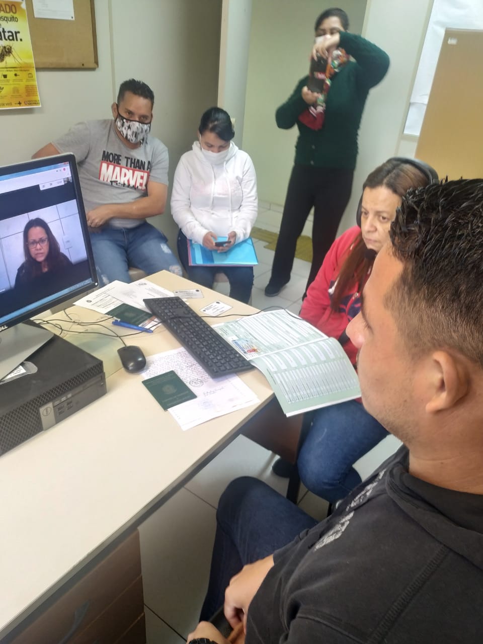 em uma sala de atendimento, surdos venezuelanos são atendidos por vídeo chamada da CIL.