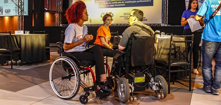 Foto de vários deficientes físicos atendendo e fazendo cadastro no Contrata São Paulo.