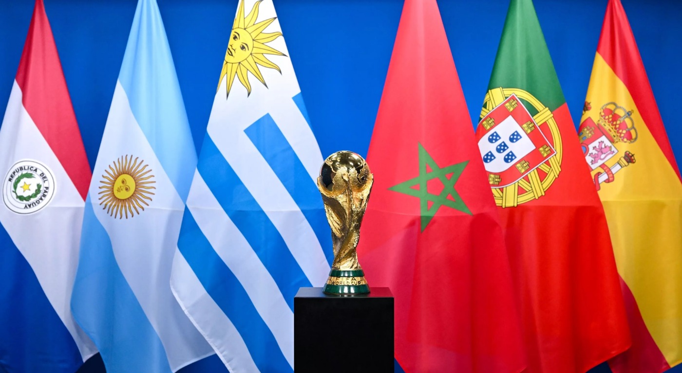 Na imagem, taça da Copa do Mundo com as bandeiras dos países sede da Copa de 2030, Paraguai, Argentina, Uruguai, Marrocos, Portugal, Espanha.