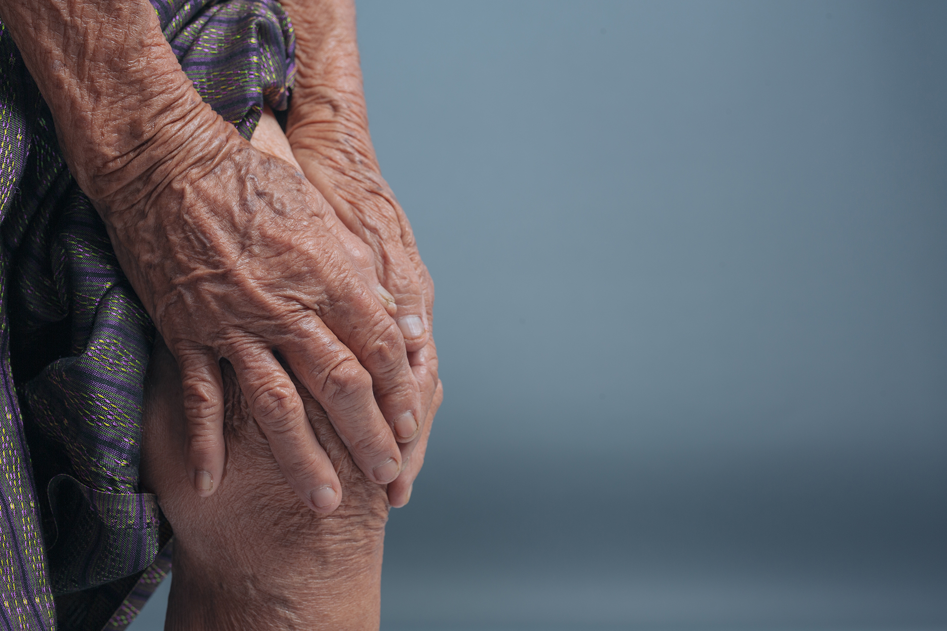 Imagem de uma pessoa idosa segurando nos joelhos