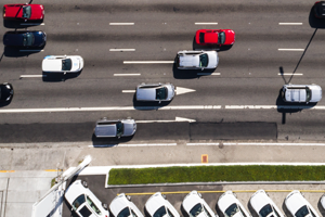 Imagem de carros em uma via vistos de cima.