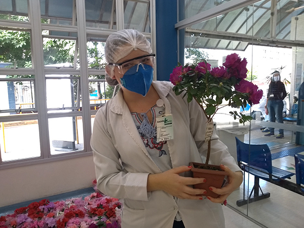 Enfermeira segurando o vaso de flor que ganhou