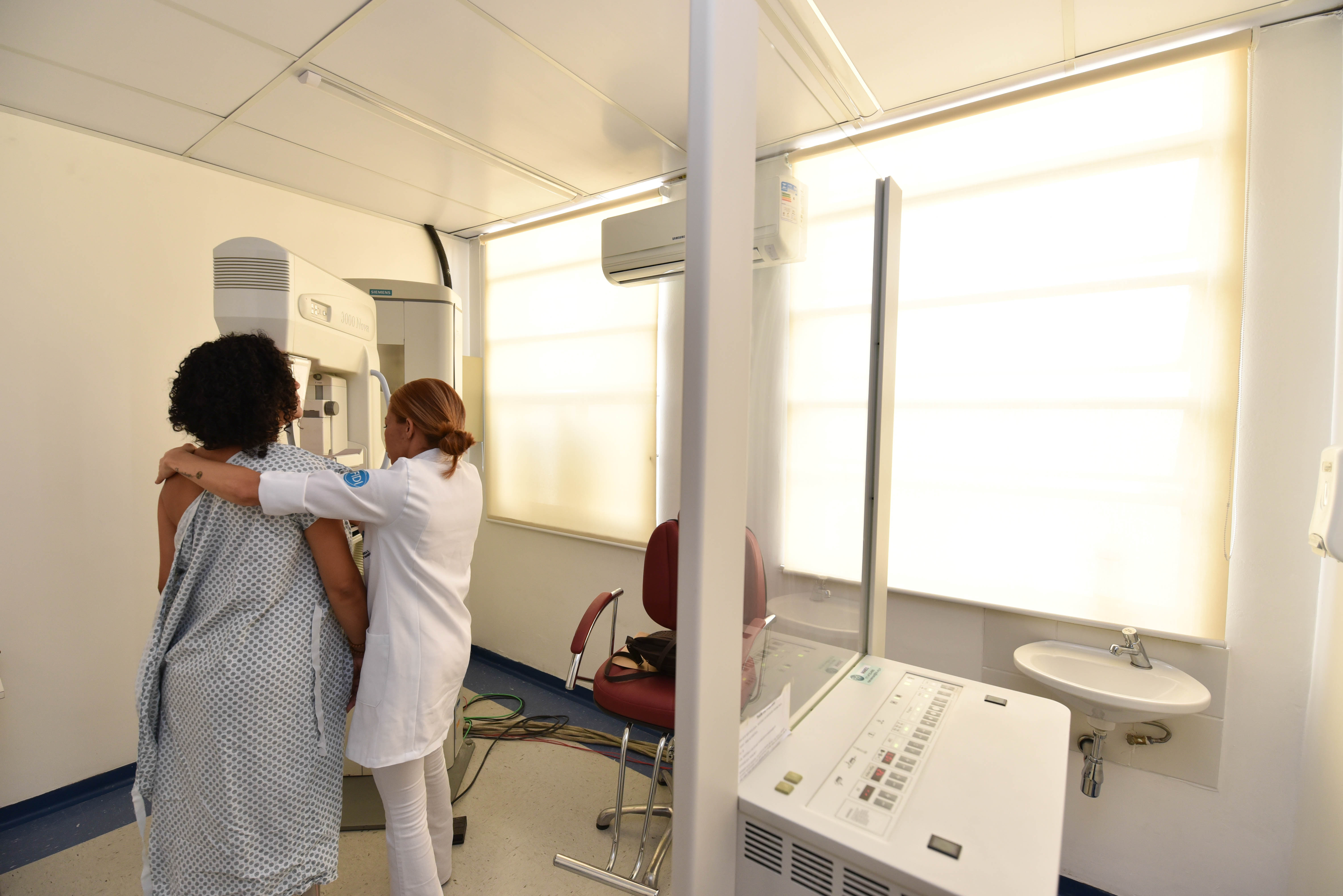 Foto de paciente realizando mamografia com profissional do HSPM