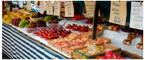 A foto mostra uma banca de feira com legumes e verduras