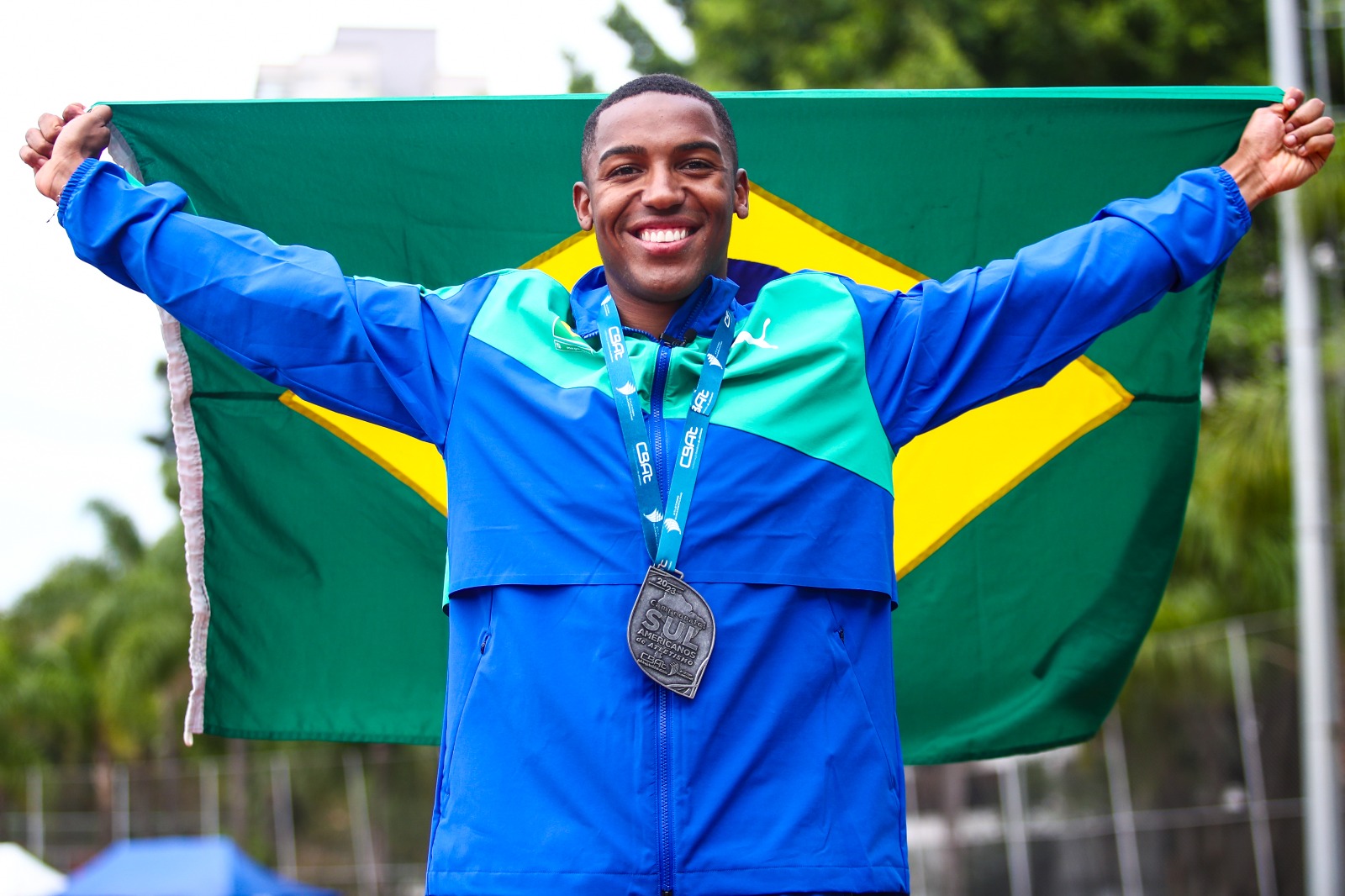 Na imagem é possível observar o atleta Erik Cardoso com a bandeira do Brasil.