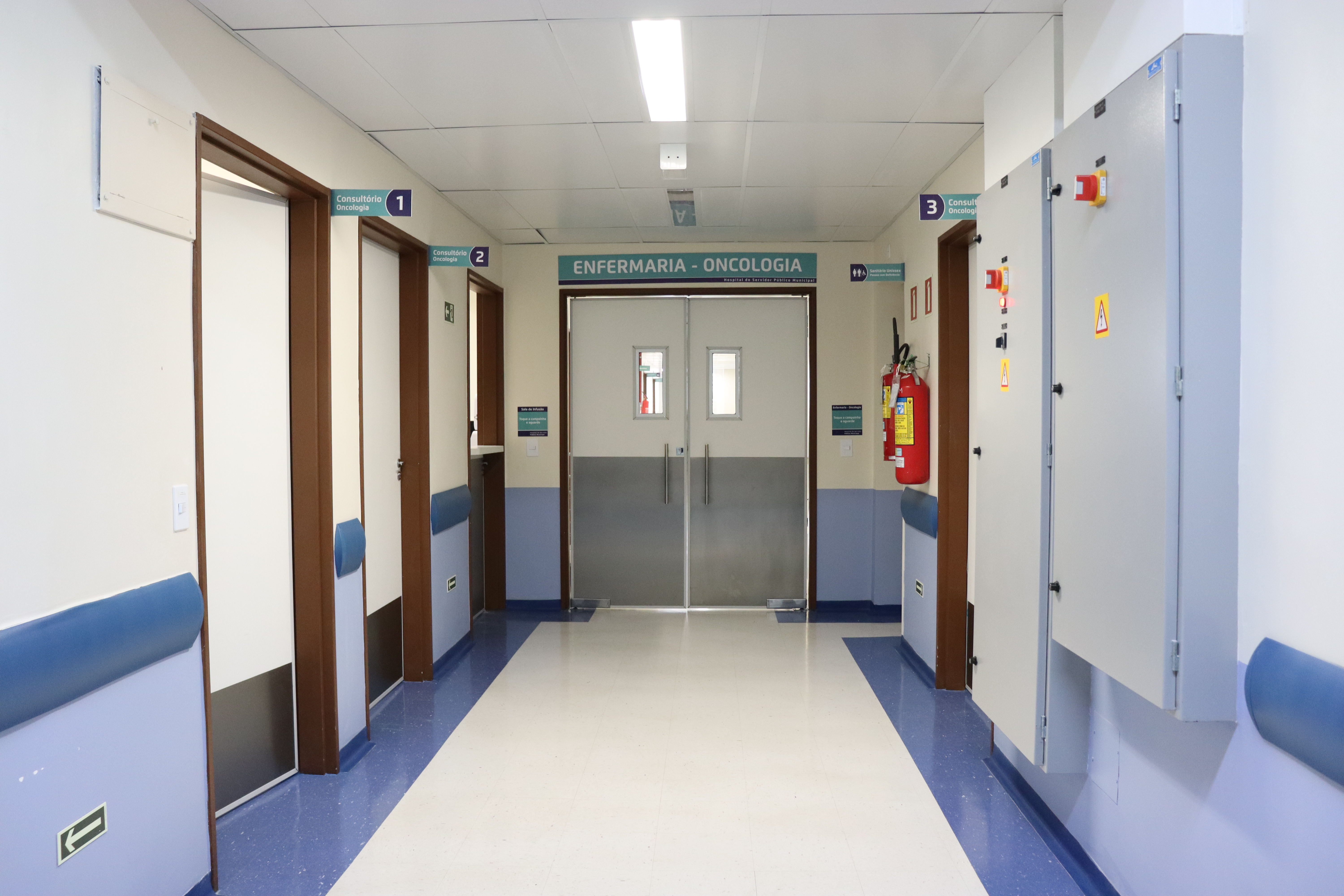 foto do corredor do hospital com a porta principal escrito consultório oncológico na parte de cima.