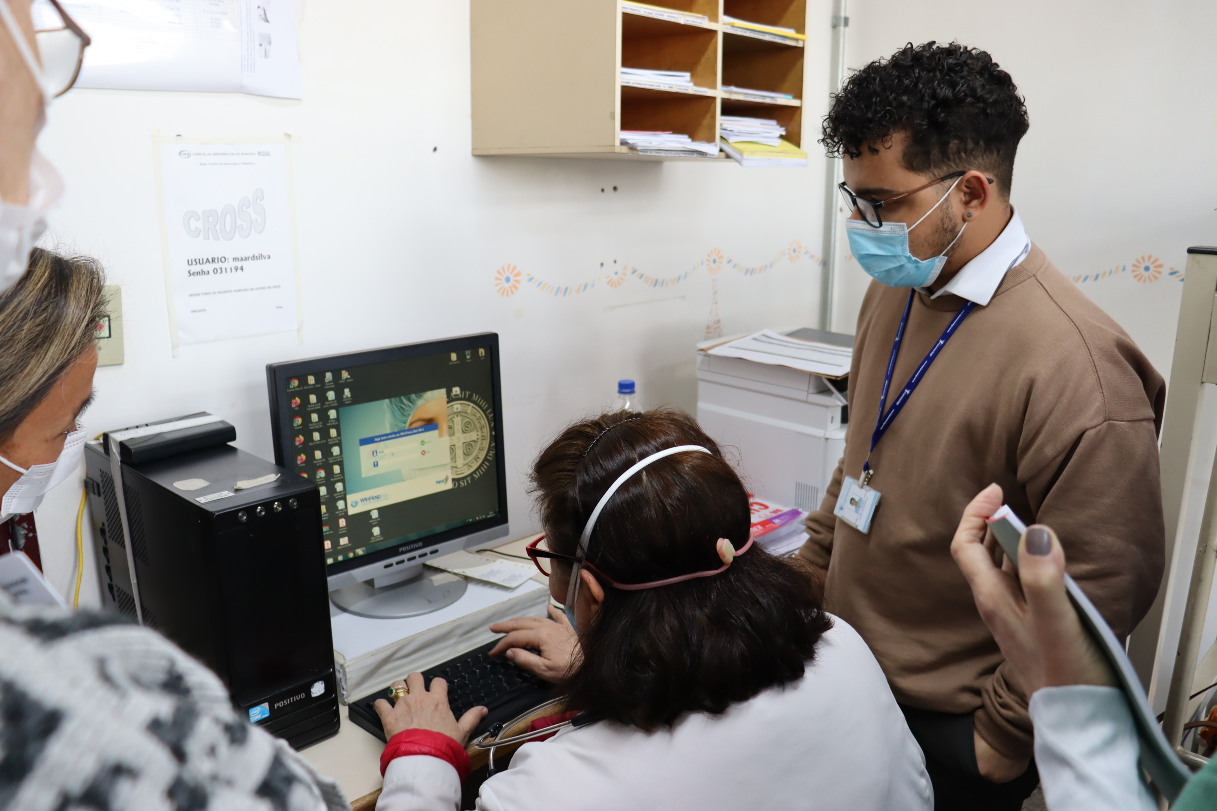 Imagem da equipe recebendo o treinamento para utilizando novo sistema nos computadores