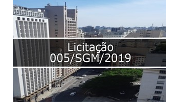 Foto tirada do centro da cidade de São Paulo, mostra rua Líbero Badaró no lado direito pedaço do Gabinete Do Prefeito De São Paulo. No meio escrito Licitação 005/SGM/2019.