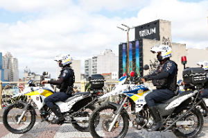#PraTodosVerem - A imagem mostra dois GCMs realizando patrulhamento com motos na cidade, numa avenida movimentada da cidade de São Paulo.