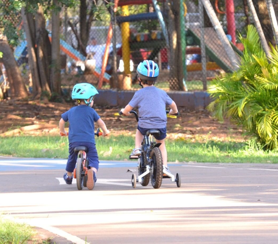 Na imagem, duas crianças andando de bicicleta no Centro Esportivo.