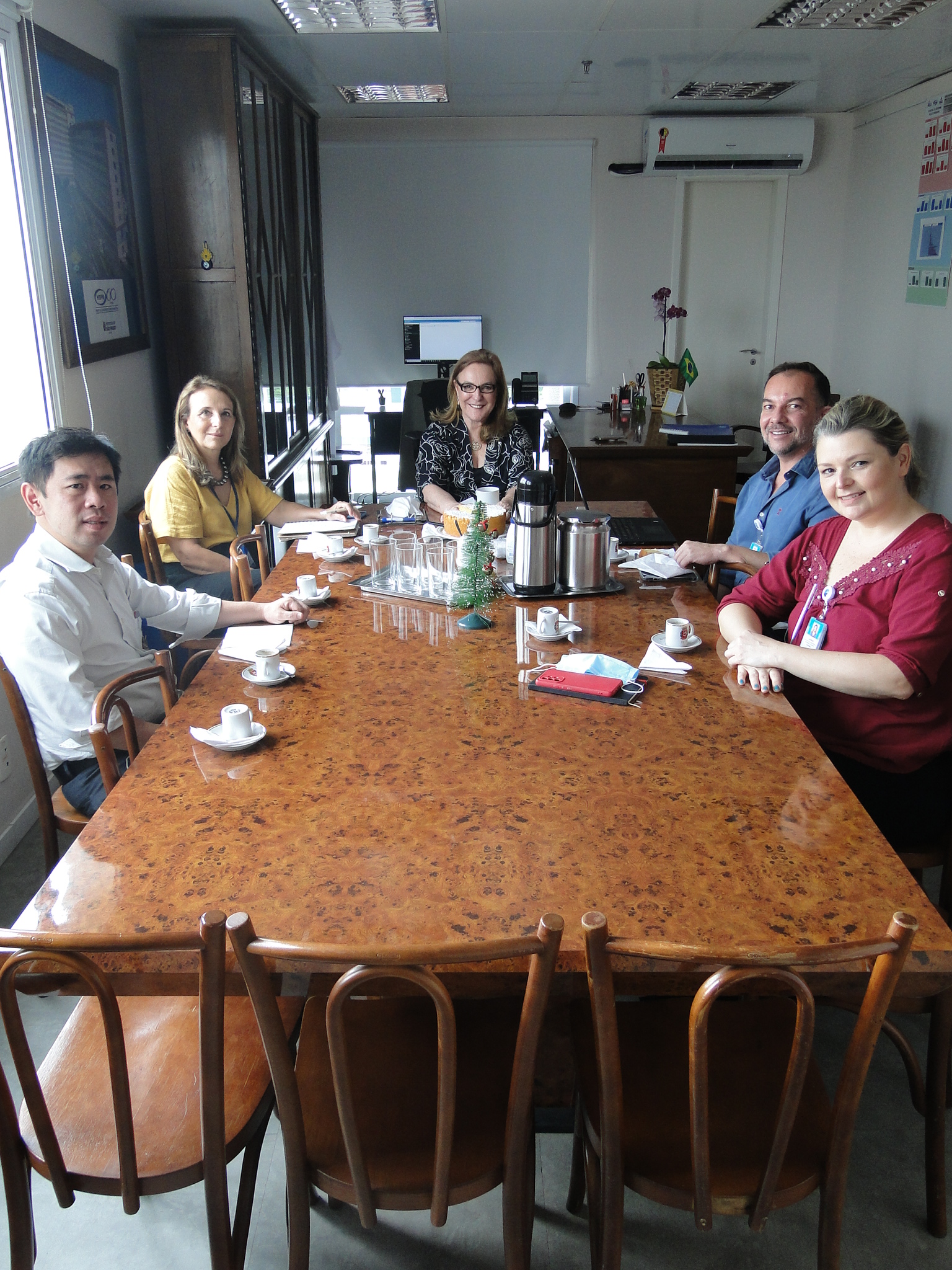 Foto dos membros do Proadi-SUS sentados à mesa, na sala de reuniões da Superintendência