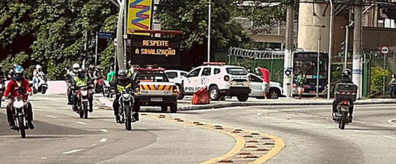 Imagem de avenida com motos e carros.