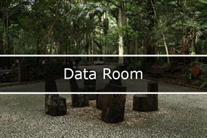 imagem dentro parque Maps, contem 6 banquinhos feito com tronco de árvores e no fundo contém várias arvores. No meio da foto escrito data room.