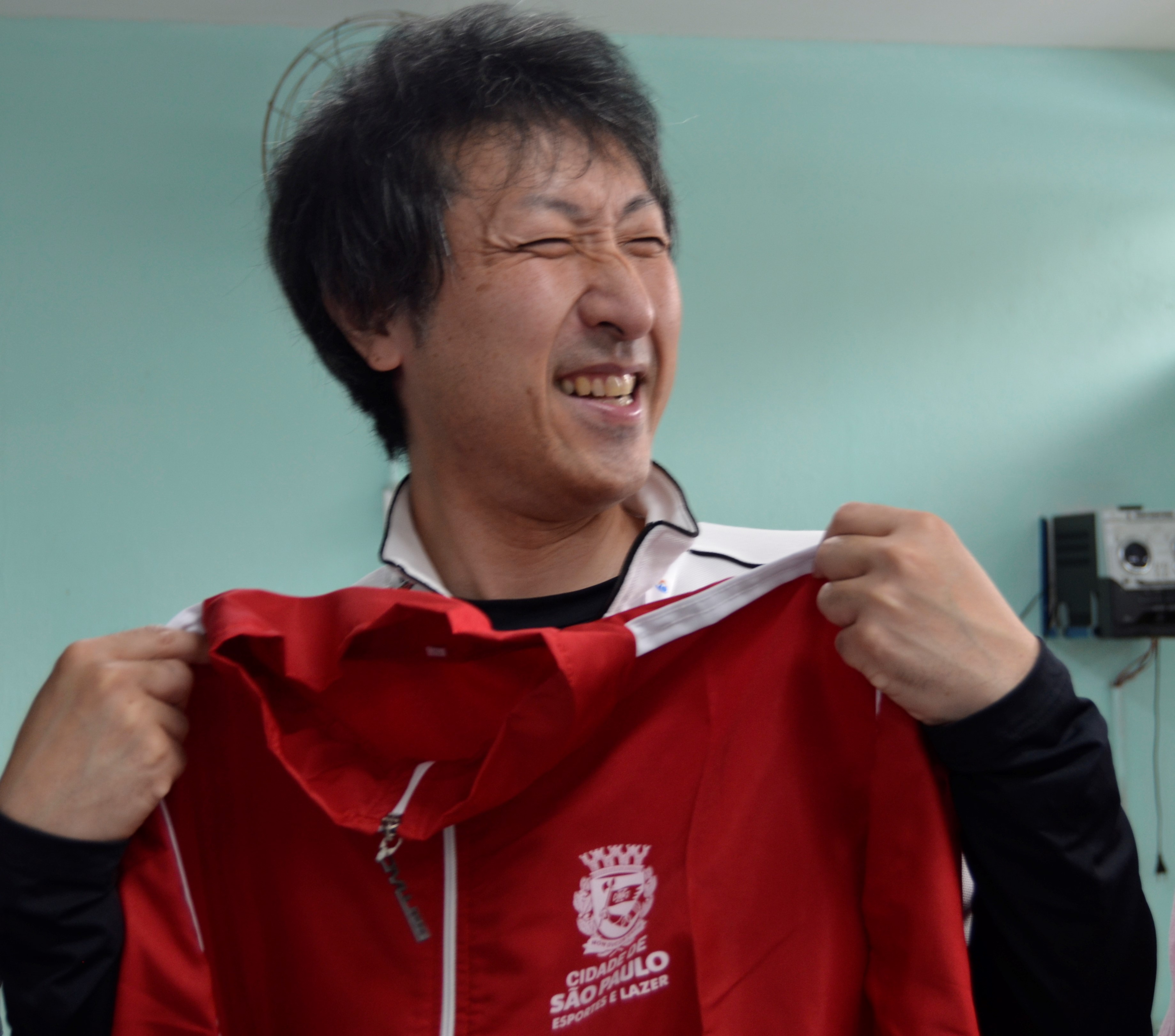 Na imagem, Sensei Yoshihito Kikuchi recebendo agasalho com logo da Secretaria Municipal de Esportes e Lazer.