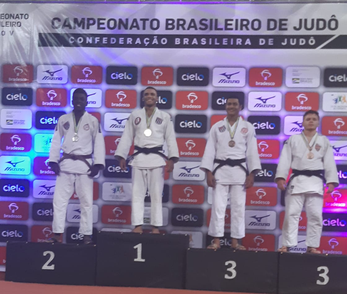 Na foto, os quatro primeiros colocados posam no pódio com suas medalhas.