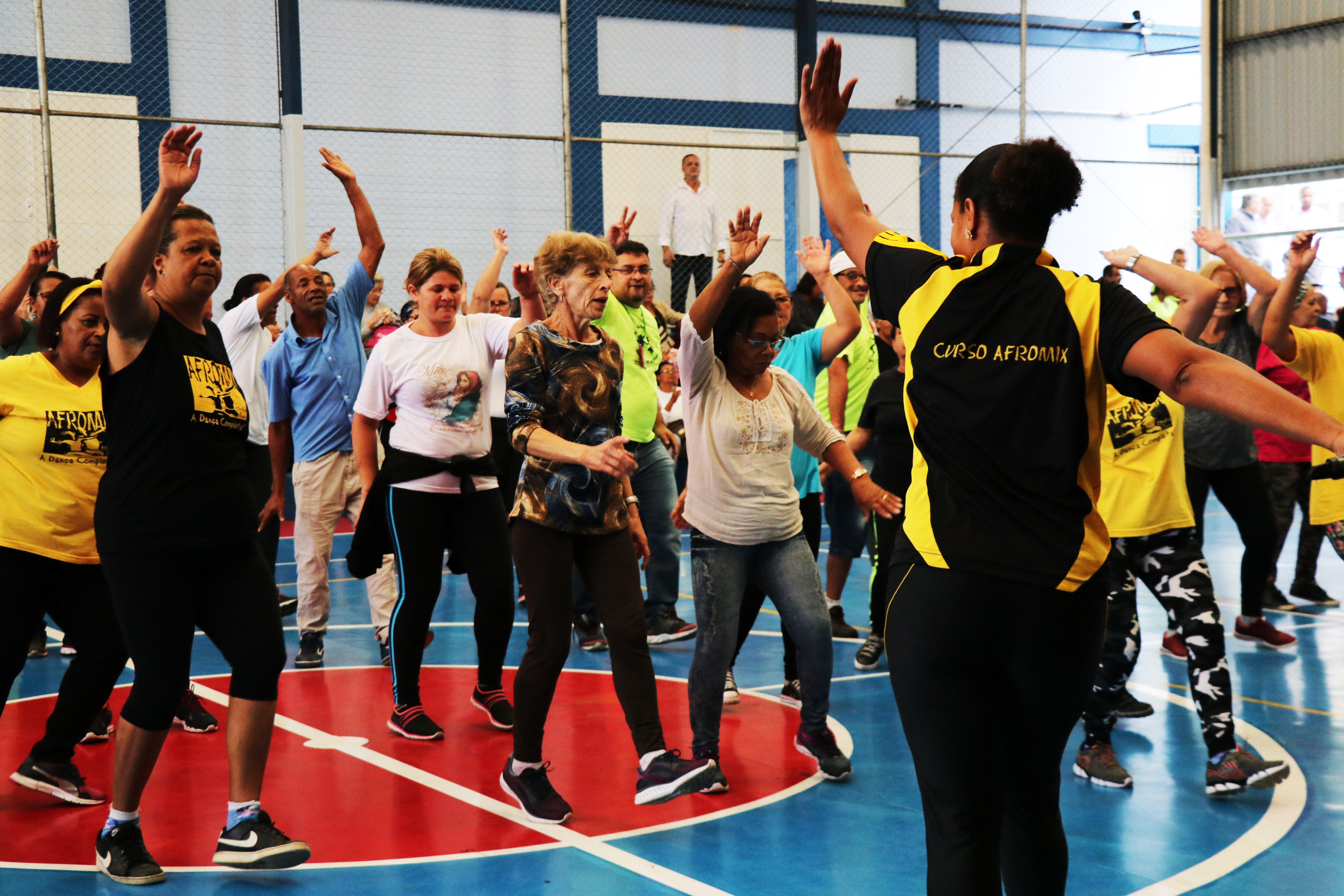 Um grande grupo de pessoas dança durante aula do Afromix no Centro Esportivo São Mateus.