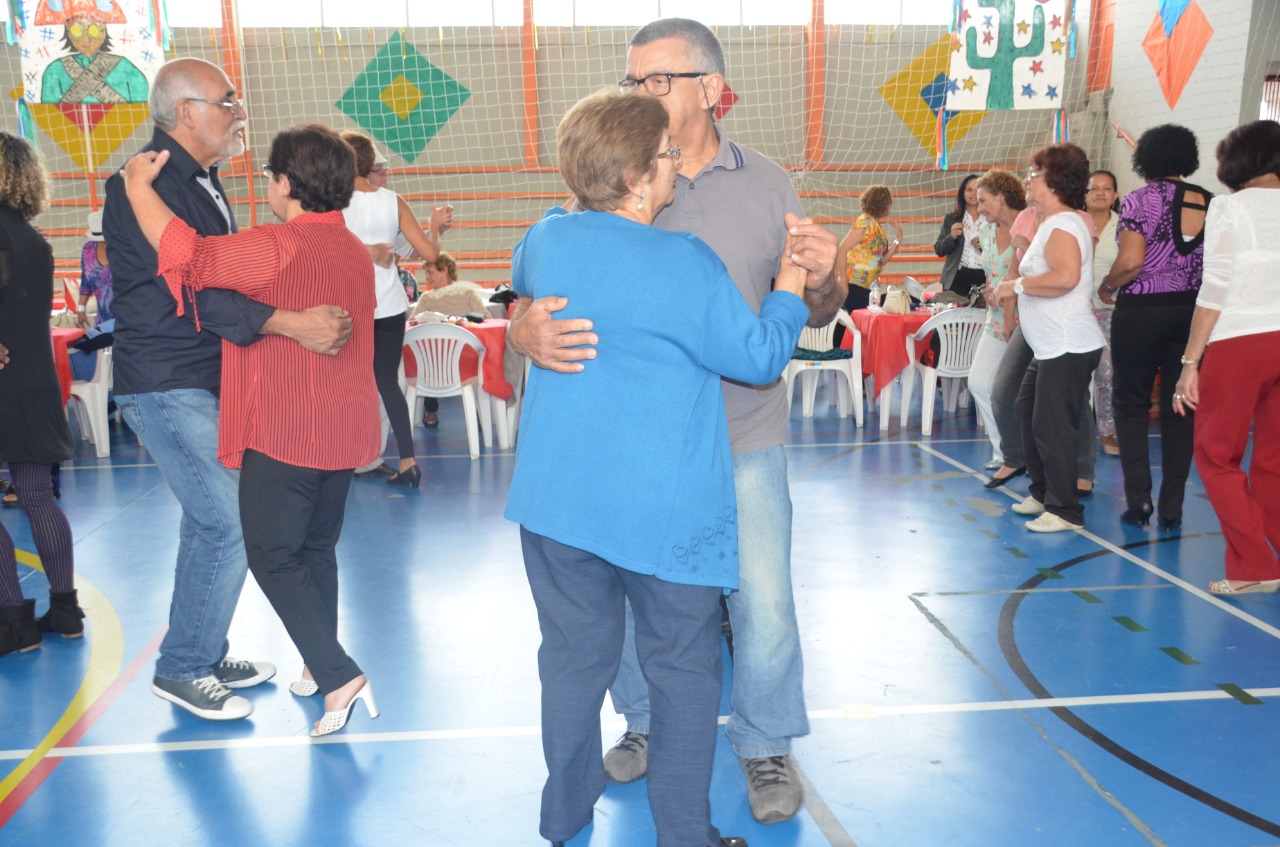 Na imagem idosos dançando em um quadra.