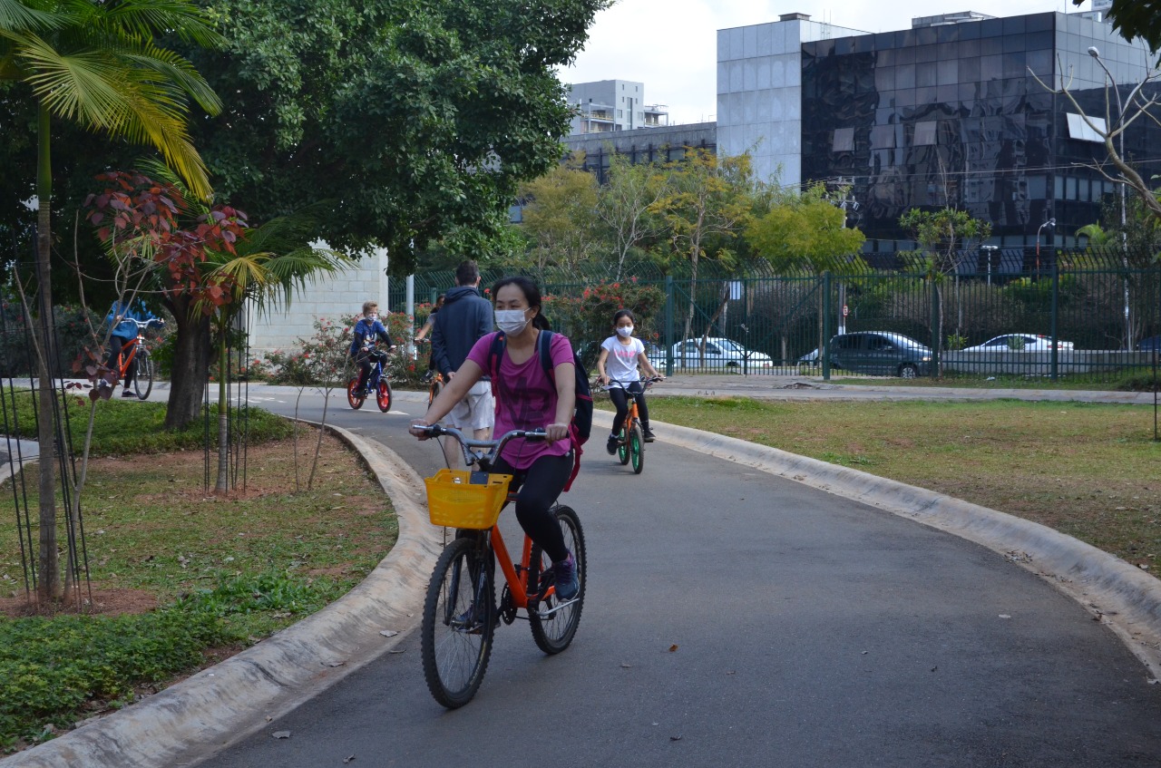 Na imagem, pessoas andando de bicicleta de máscara no Parque das Bicicletas.