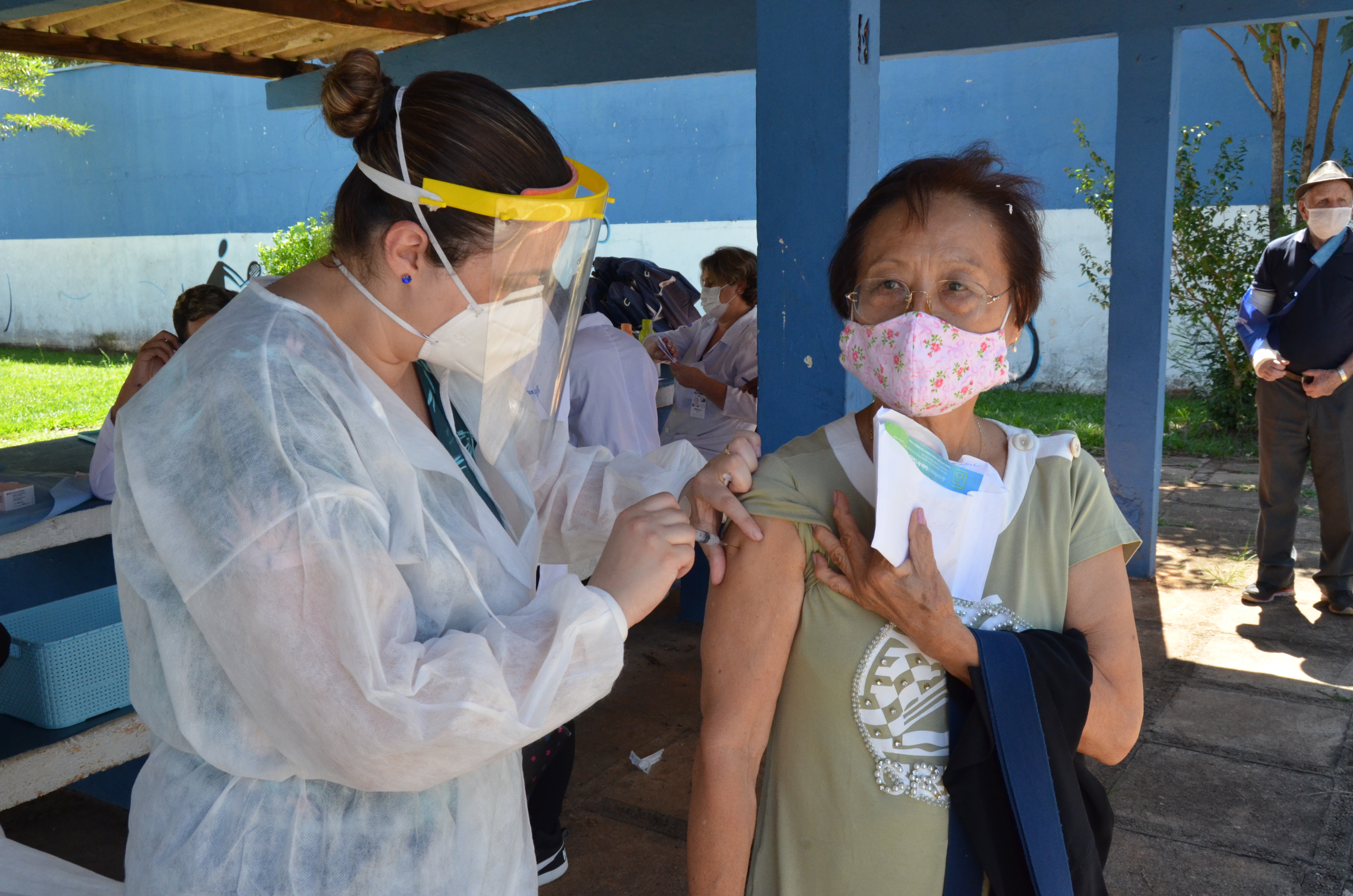 Na imagem, a enfermeira aplicando a vacina contra o Coronavírus em uma idosa.