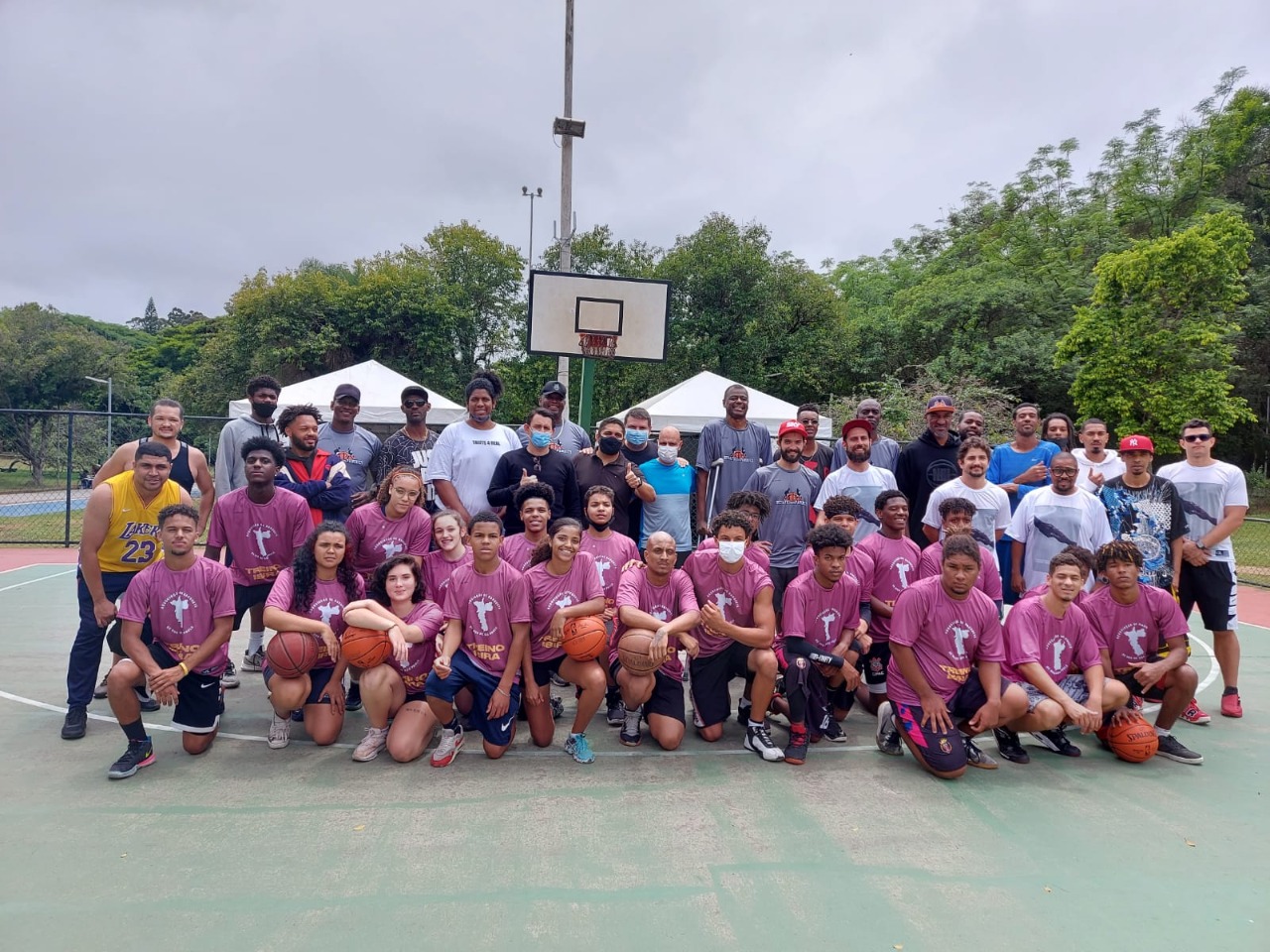 Na imagem, atletas de basquete posam para foto em grupo.