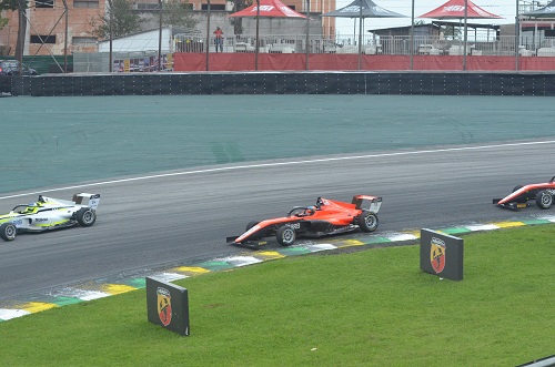 Na imagem, carros da Fórmula 4 na pista, disputando posição.