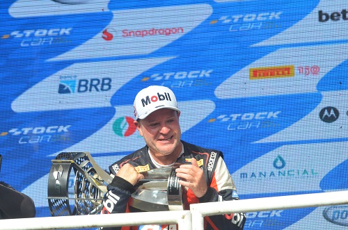 Na imagem, Rubens Barrichello abraçado com o troféu de campeão no pódio.