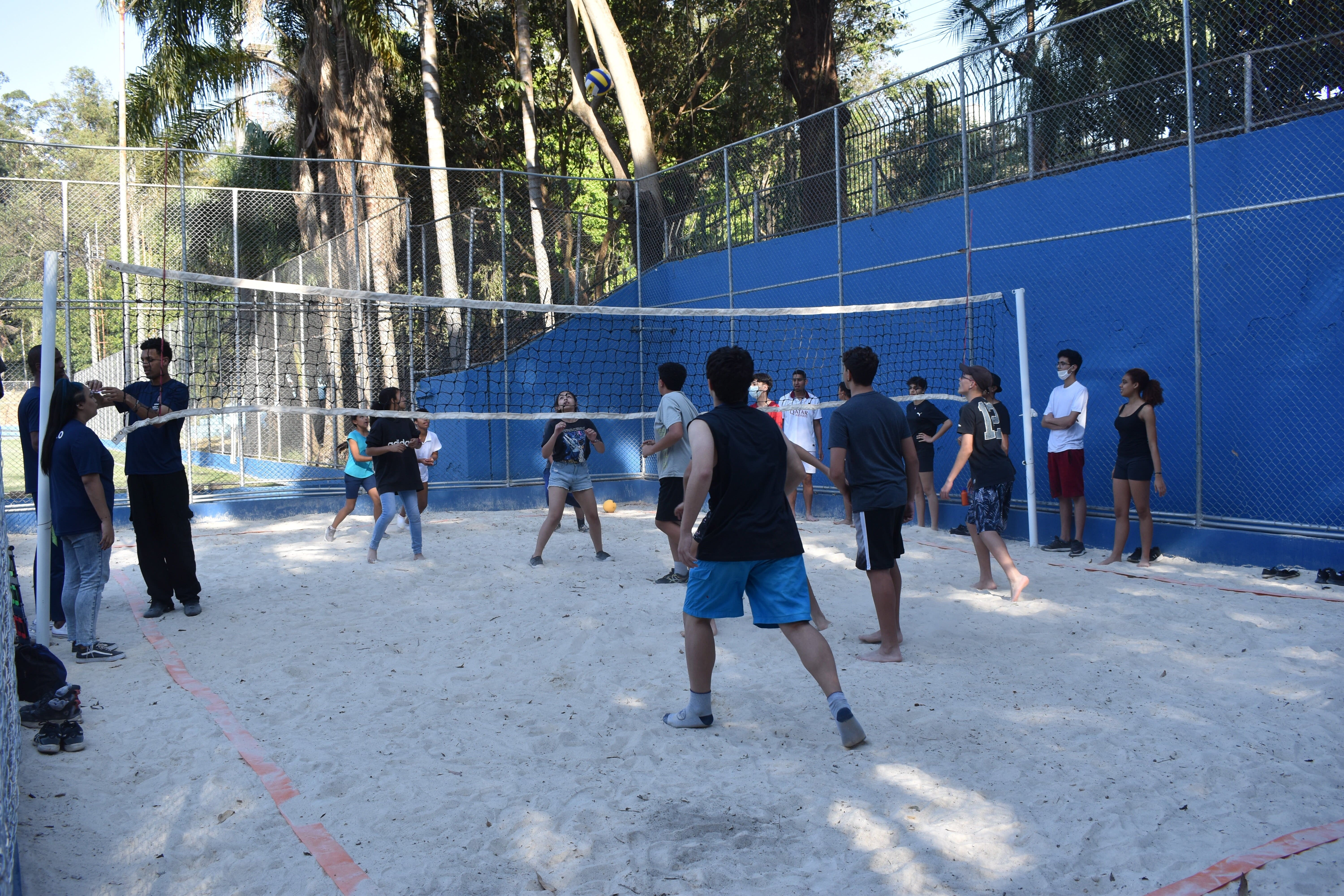 Na imagem, pessoas jogando vôlei 