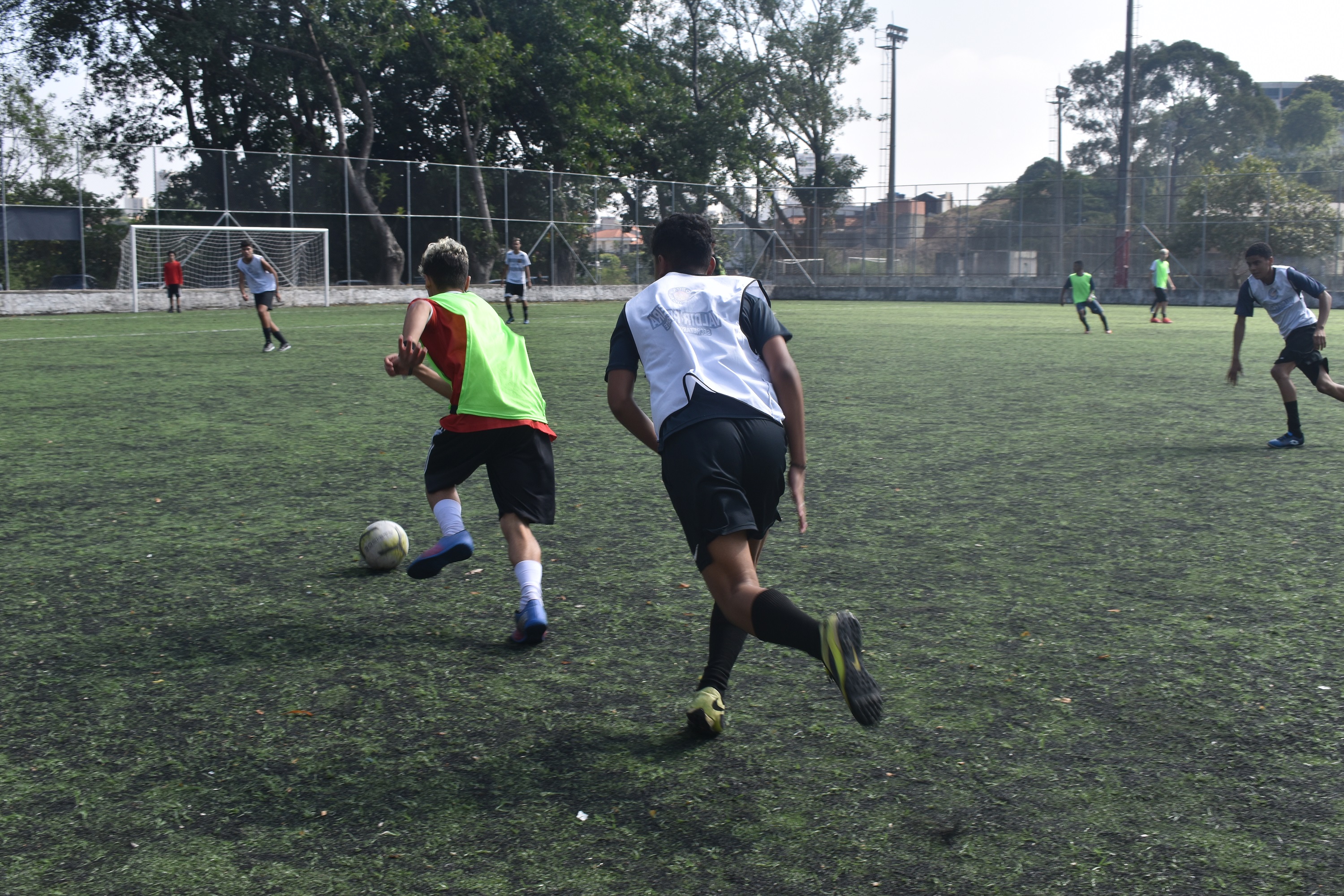 Na imagem, crianças jogando futebol no campo do Clube da Comunidade Vila Formosa.