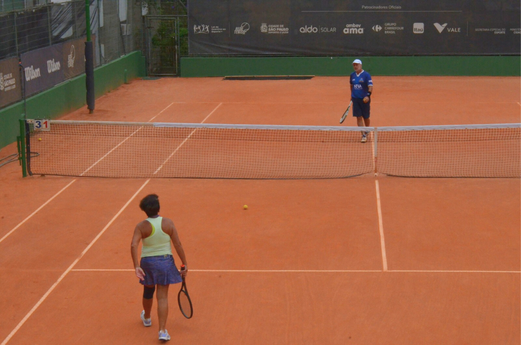 Na imagem, participantes jogando tênis no Jogos Municipais da Pessoa Idosa 2023.