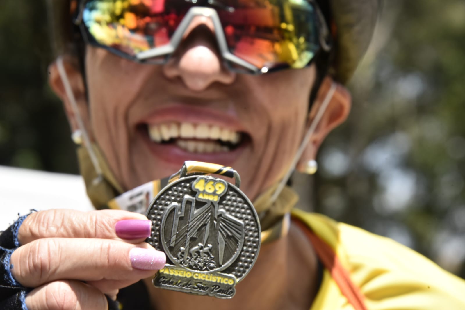 Na imagem, participante do Passeio Ciclístico  mostrando a medalha no Aniversário da Cidade de São Paulo
