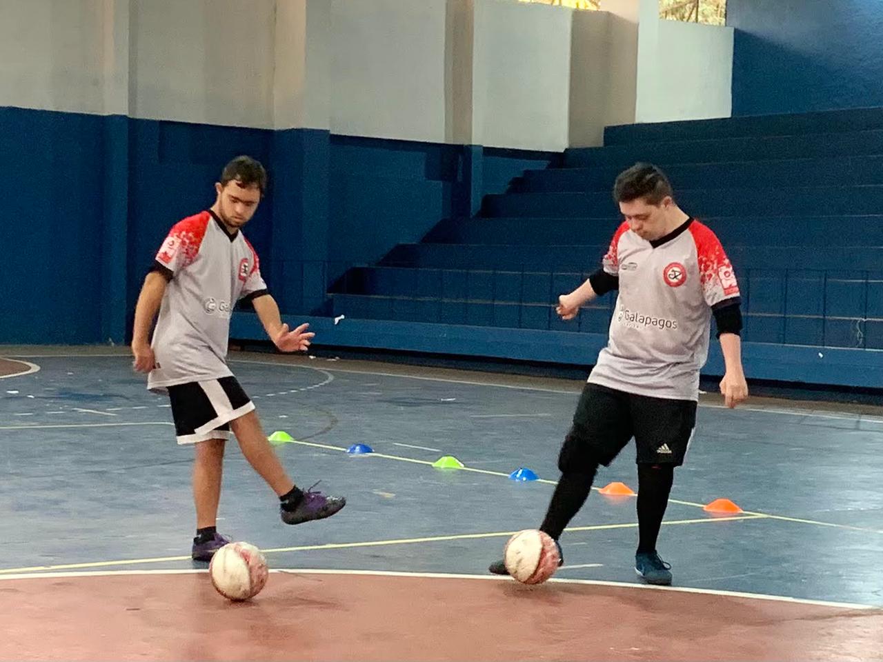 Na imagem, munícipes com down participando da aula de futsal.