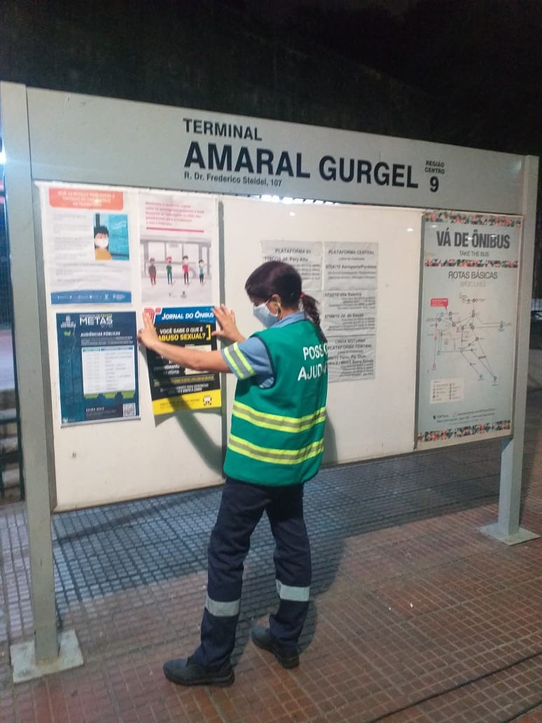 funcionário da prefeitura colando cartaz no terminal Amaral Gurgel