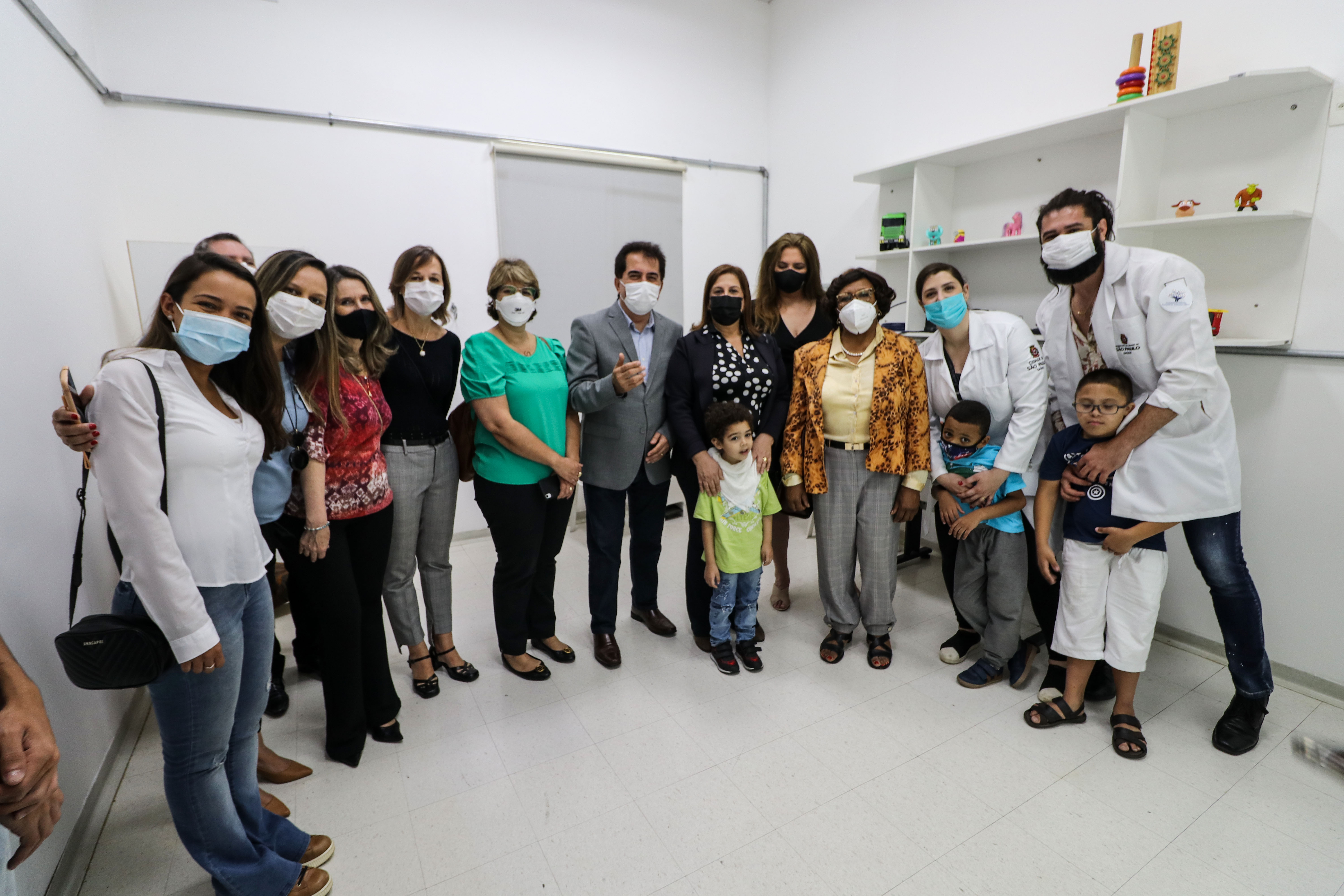 Em uma sala com paredes brancas está a secretária Silvia Grecco acompanhada de crianças, representantes do CER Tucuruvi II e autoridades.