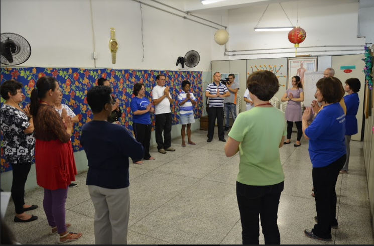 Um grupo de pessoas está organizado em círculo numa sala.