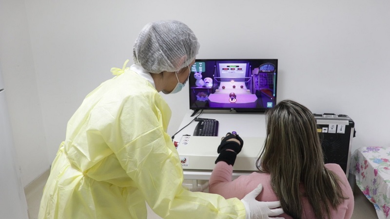 #PraCegoVer: paciente acompanhada de profissional da saúde utiliza tecnologia robótica 