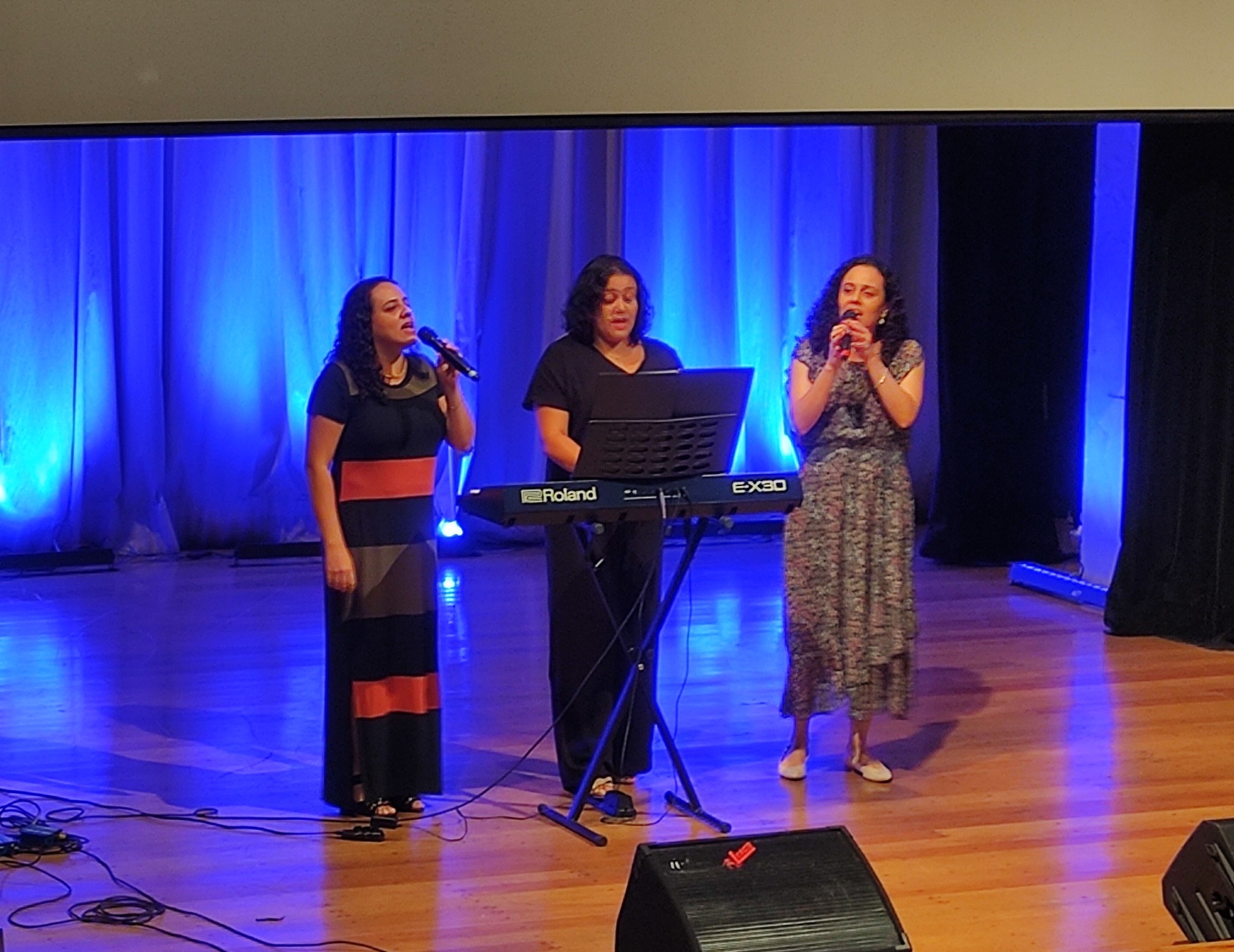 A servidora Emilia de Moura Silva Araújo se apresenta no palco junto com a sua irmã, Ana Maria de Souza Silva, e sua amiga, Tatiana Silva Arakaki.