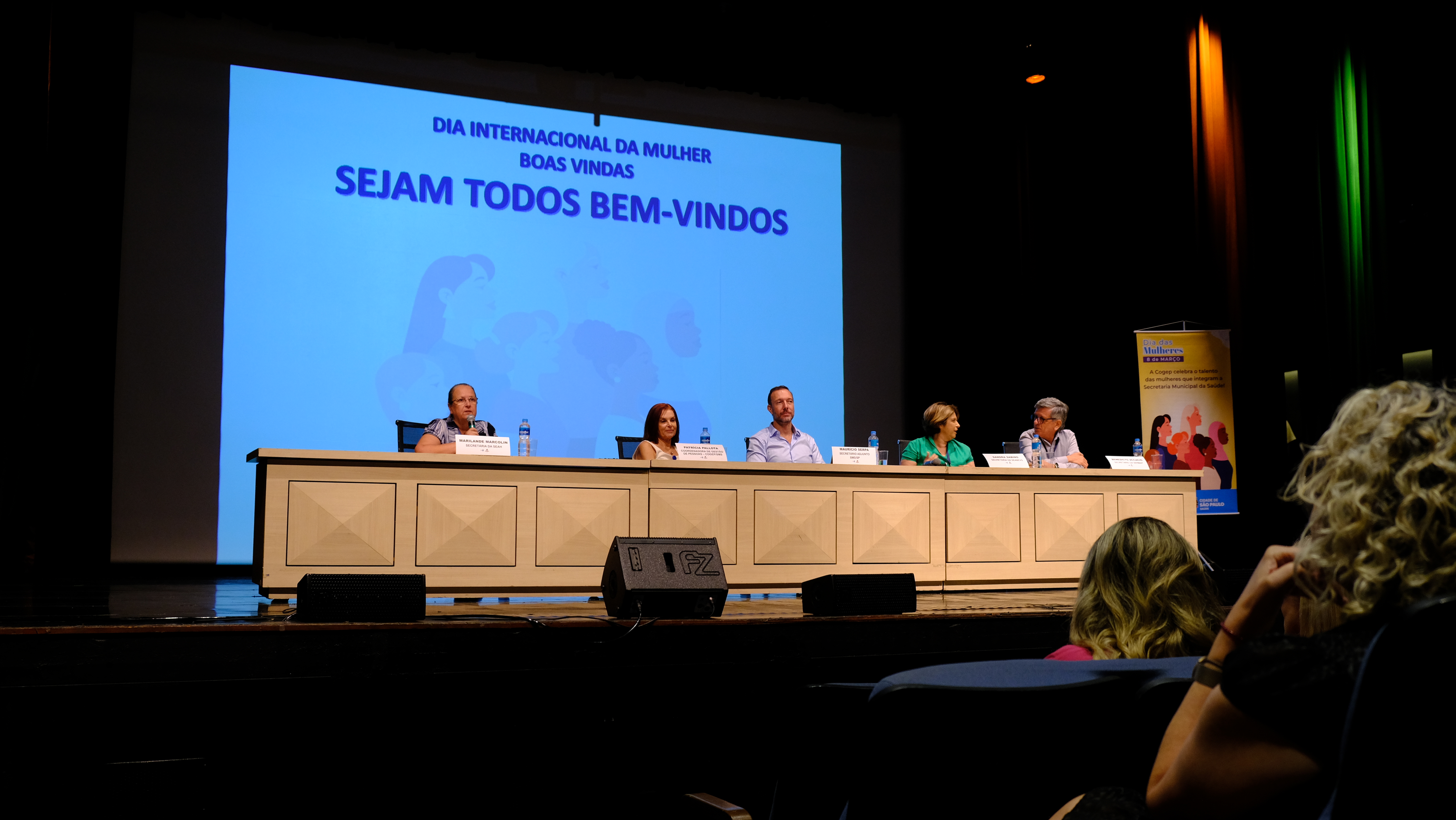 Na imagem está uma mesa localizada no centro da imagem. Sentada a ela estão: Maurício Serpa, Sandra Sabino, Marilande Marcolin, Patrícia Pallota e o Benedicto Accacio